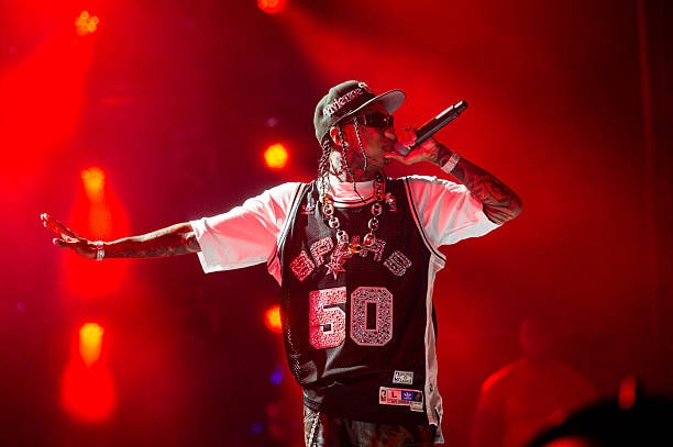 Rapper performing on stage with red lights