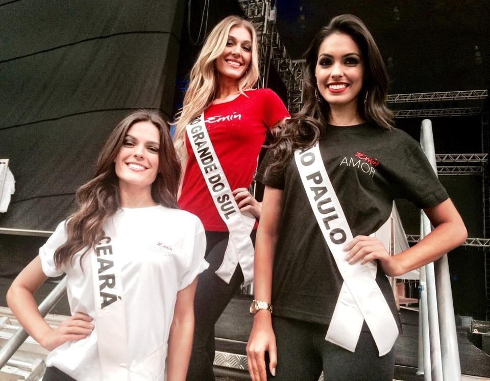 Beauty pageant contestants posing together backstage