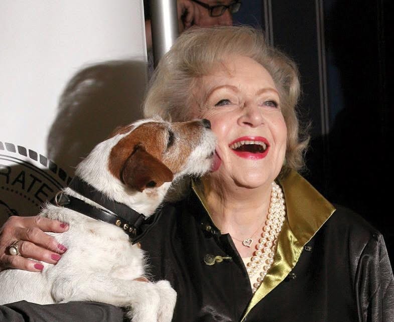 Woman laughing with dog at event