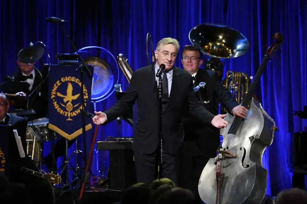 Man speaking at microphone with jazz band